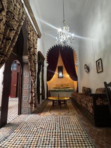 un soggiorno con un divano e un lampadario di Hotel Dar Dalia Tetouan a Tétouan