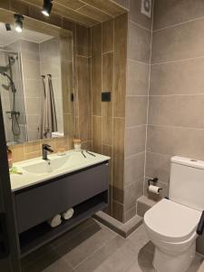 Un baño con lavabo, inodoro y espejo. en Barrio Italia Hermoso Departamento mas Parcking Gratis y Wifi, en Santiago