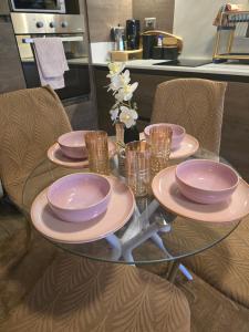 Una mesa de cristal con tres platos y vasos encima. en Barrio Italia Hermoso Departamento mas Parcking Gratis y Wifi, en Santiago