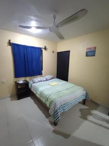 a bedroom with a bed and a blue curtain at Las Villas Champoton in Champotón