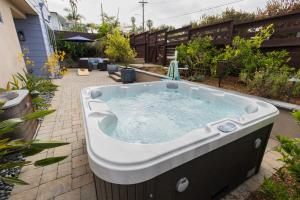 a jacuzzi tub in the backyard of a house at Leucadia Oasis with Spa, EV, Fire Pit, AC, Walk to Beach in Encinitas