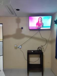 a flat screen tv hanging on a wall with a table at Las Villas Champoton in Champotón +3 photos