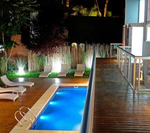 a swimming pool in the middle of a patio with chairs at Arenas Calidas Carilo in Carilo +12 photos
