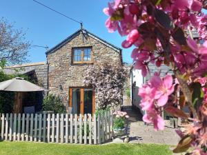 a stone house with a fence and flowers at 2 Bed in Kilkhampton TRDAI in Kilkhampton