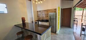 a kitchen with a counter and a refrigerator at Sincorá Guesthouse in Lençóis