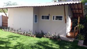 a small white house with a grass yard at Sincorá Guesthouse in Lençóis
