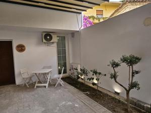 a patio with a table and chairs next to a building at TRE'S BLISS City Heart Villa!!! in Durrës