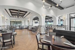 una sala da pranzo con tavoli, sedie e finestre di Private Villa at Corte Bella Country Club a Sun City West