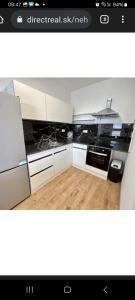 a kitchen with white cabinets and black counter tops at Apartment brand new in Seredʼ +2 photos