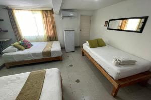a bedroom with two beds and a refrigerator at Isla Mujeres Punta Norte Private Bedroom 2 in Isla Mujeres