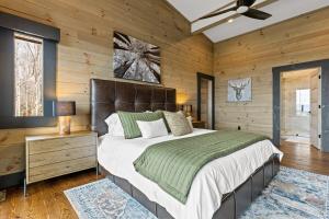 ein Schlafzimmer mit einem großen Bett und Holzwänden in der Unterkunft Ultra Luxury Cabin, Stunning Mtn Views, Game room in Mineral Bluff