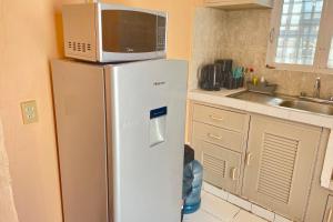 a microwave on top of a refrigerator in a kitchen at Central Studio With Balcony & Kitchen in Isla Mujeres
