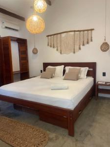 a bedroom with a large bed with white sheets at Casas Oceanicas in Icaraí