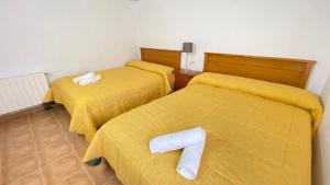 two beds with yellow sheets with a number seven on them at Casa azul in Nerpio
