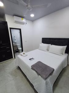 a bedroom with a white bed with a towel on it at Hotel Internacional Boutique Milan in Puerto Boyacá +6 photos
