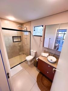 a bathroom with a shower and a toilet and a sink at Moderno Loft Urban Beach em Itajai - SC -Praia do Atalaia in Itajaí +16 photos