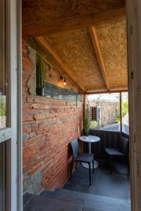 a brick wall with a table and chairs on a patio at Затишна студія біля метро Площа Конституції - Харківська набережна 3-10 in Kharkiv