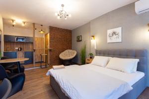 a bedroom with a large bed and a dining room at Затишна студія біля метро Площа Конституції - Харківська набережна 3-10 in Kharkiv
