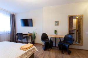 a room with a bed and a table and chairs at Затишна студія біля метро Площа Конституції - Харківська набережна 3-10 in Kharkiv +9 photos