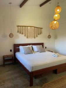 a bedroom with a large bed with white sheets at Casas Oceanicas in Icaraí