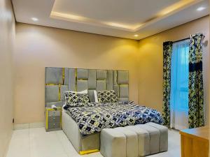 a bedroom with a bed with a headboard at GRACE LODGE LEKKI Phase 1 in Araromi