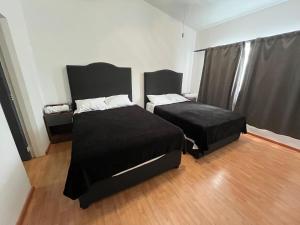 a bedroom with two beds and a chair at 23 Habitación doble cama in Miravalle