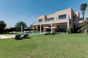 una casa con un gran patio con piscina en Villa La Baraca, en Marrakech