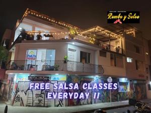 Un edificio con un cartel que dice clases de salsa gratis todos los días. en La Familia Hostel - Parque Poblado, en Medellín