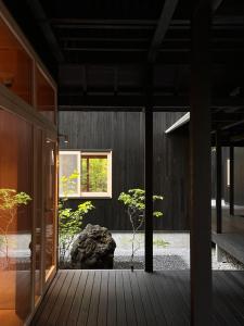 a house with a wooden porch with a plant at SHISHI-IWA HOUSE Karuizawa in Karuizawa