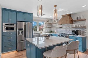 una cocina azul con electrodomésticos de acero inoxidable y armarios azules en The Smith Haus - Sleeps 12 Pool Game Room, en Fredericksburg 48 fotos más