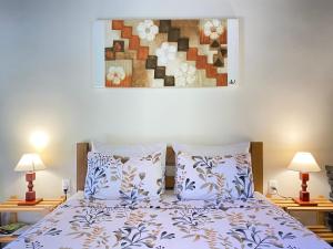 un letto con due cuscini e un dipinto sul muro di Namata CHALÉS a Lumiar