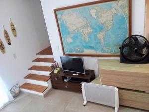 a room with a desk with a television and a map on the wall at Hostel Italia Fisherton in Rosario