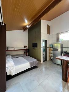 a bedroom with a bed and a refrigerator at Chalé Suítes Casa na Praia de Itamambuca in Ubatuba