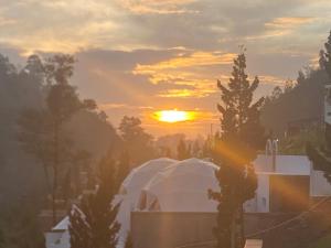a sunset over a building with a white tent at Kawoeng kabin in Panjadakan