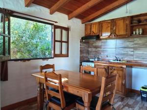 a kitchen with a wooden table and a window at Cabaña Las liebres in San Roque