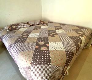 un letto con una trapunta in una stanza di Salt Beach Guest House Atalaia a Salinópolis