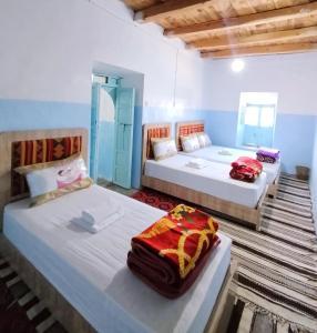 two beds in a room with two bedsitures at Tagmat guest house in Toufrine