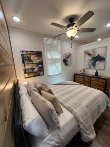 een slaapkamer met een bed met een plafondventilator bij Barn Door Themed Garvan Gardens Blue Bungalow in Hot Springs