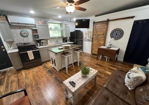 een keuken en woonkamer met een bank en een tafel bij Barn Door Themed Garvan Gardens Blue Bungalow in Hot Springs