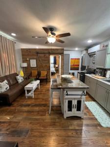 een keuken en een woonkamer met een plafondventilator bij Barn Door Themed Garvan Gardens Blue Bungalow in Hot Springs +9 foto's