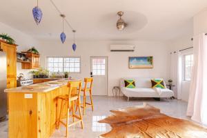 a kitchen with a table and chairs and a couch at Free Shuttle & Cruise Sexy Roof Top Pool Ocean View in Negril