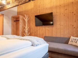 a bedroom with a bed and a tv on a wall at Hausa Sommer in Grossarl