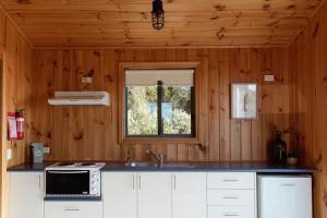 a kitchen with a sink and a window at Panorama Cabin - B in Bicheno