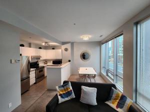 a living room with a couch and a kitchen at Cozy Condo in the heart of the city in Vancouver