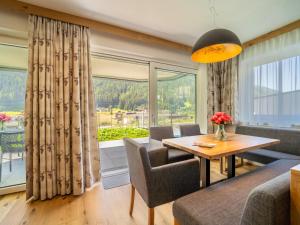 圣安东阿尔贝格Chalet Pettneu am Arlberg - Top 1的带桌子和大窗户的客厅