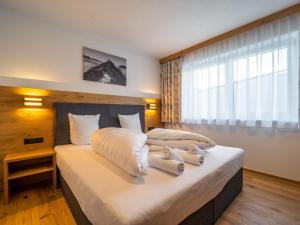 圣安东阿尔贝格Chalet Pettneu am Arlberg - Top 1的卧室里有一张大床，床上铺着毛巾。