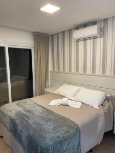 a bedroom with a bed with two towels on it at Apartamento Bolognese in Canela