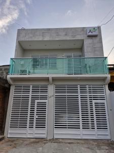 a house with a balcony on top of it at Açaí Hostel in Belém