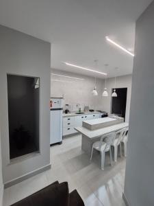 a large white kitchen with a table and chairs at Açaí Hostel in Belém +22 photos
