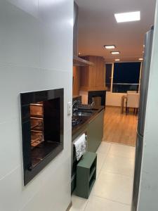 a kitchen with a stove top oven in a room at Apartamento Bolognese in Canela +5 photos